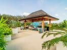 Spacious outdoor patio with wooden gazebo and tropical plants