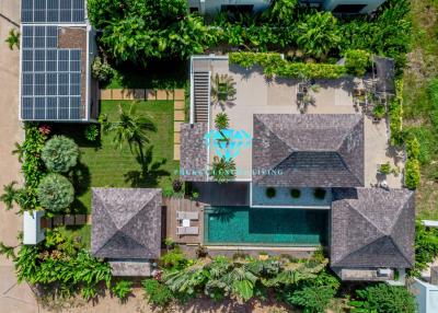 Aerial view of a luxury property with solar panels and swimming pool