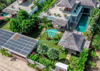 Aerial view of a luxurious residential property with lush greenery and solar panels