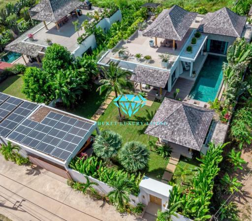 Aerial view of a luxurious residential property with lush greenery and solar panels