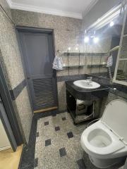 Compact bathroom with modern fixtures, tiled flooring, and mirror