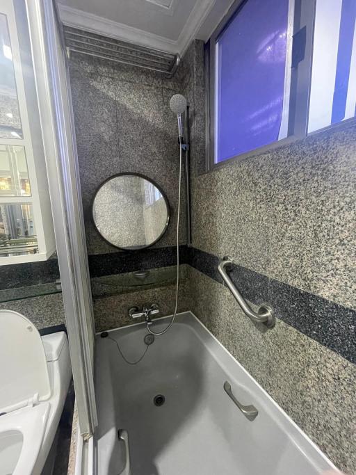 Modern bathroom with granite walls and a bathtub