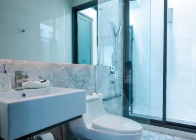 Modern bathroom with marble finish and glass shower enclosure