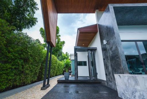 Modern home entrance with wooden ceiling and marble accents