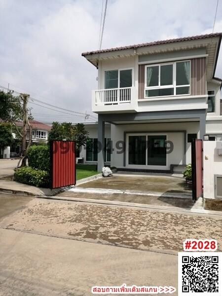 Modern two-story home with balcony and concrete driveway