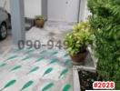 Blurry image of a residential exterior pathway leading to a white door with potted plants