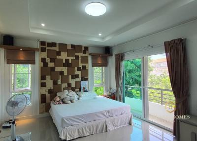 Spacious bedroom with modern design, large bed, and ample natural light from the window