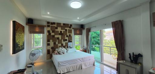 Spacious bedroom with modern design, large bed, and ample natural light from the window