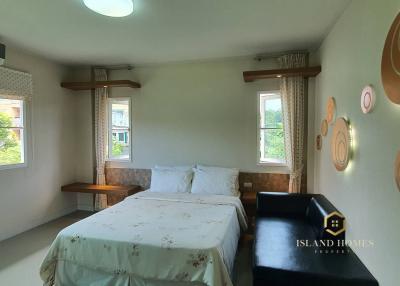 Bright and airy bedroom with large windows, comfortable bed and modern air conditioning unit