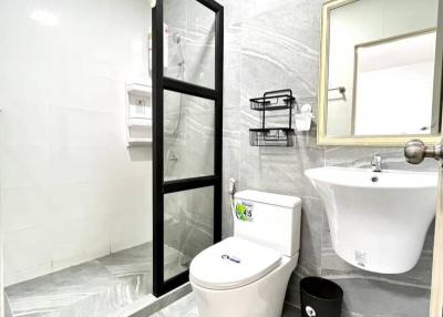 Modern white-tiled bathroom with glass shower enclosure