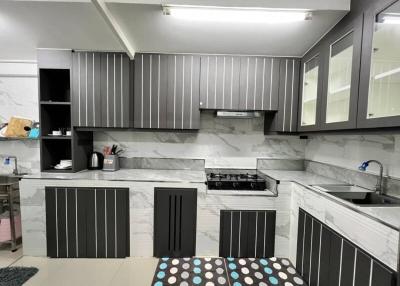 Modern kitchen with gray cabinetry and marble countertops