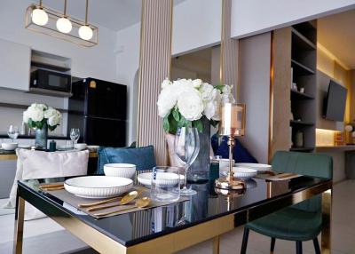 Modern dining area with open-plan kitchen in the background