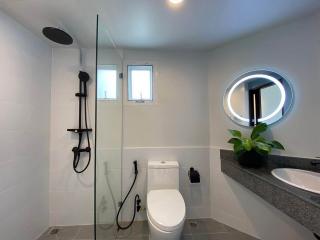 Modern bathroom with walk-in shower, toilet, and vanity