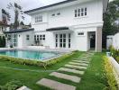 White modern house with swimming pool and green lawn
