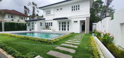 White modern house with swimming pool and green lawn