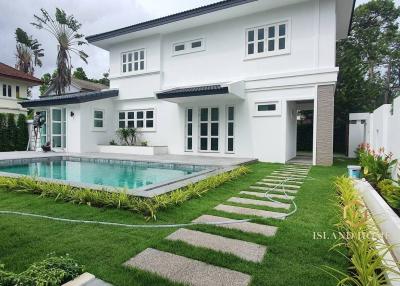 White modern house with swimming pool and green lawn