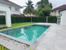 Spacious backyard with a swimming pool and tiled patio area