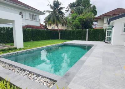 Spacious backyard with a swimming pool and tiled patio area