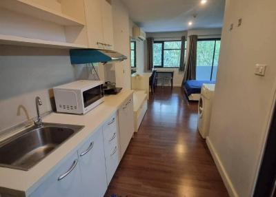 Compact kitchen with modern appliances and hardwood flooring