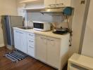 Compact kitchen with appliances and white cabinetry