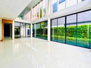 Spacious and bright lobby area with floor-to-ceiling windows and garden view