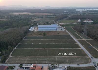 Aerial view of a rural landscape with farmland, buildings, and mountains in the distance