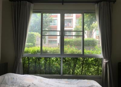 Bright bedroom with large window showing garden view