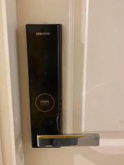 Modern Samsung digital door lock on a white door