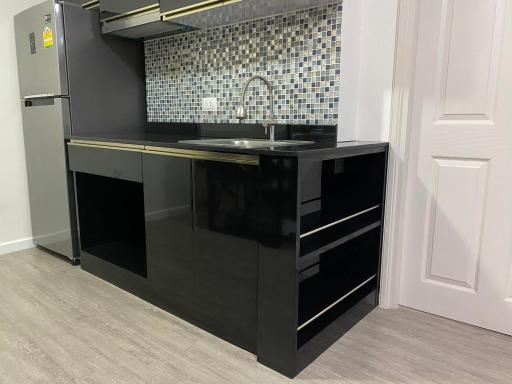 Modern kitchen interior with black cabinetry and mosaic backsplash