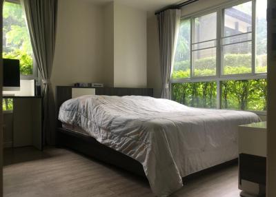 Cozy bedroom with natural light overlooking greenery