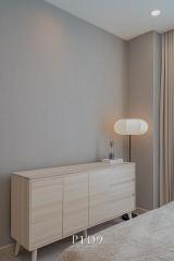 Modern bedroom interior with stylish dresser and elegant lamp