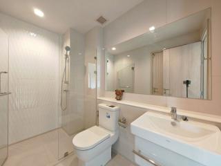 Modern bathroom interior with glass shower, vanity, and well-lit mirror