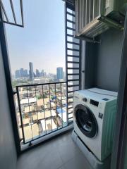 Compact balcony with washing machine and city view