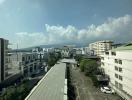 Urban landscape view from a building showing other buildings, street, and mountains in the distance