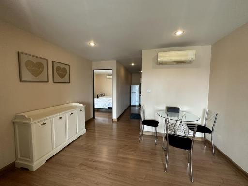 Open concept living area with dining set and view into bedroom