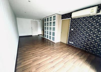 Spacious living room with dark wooden flooring and air conditioning