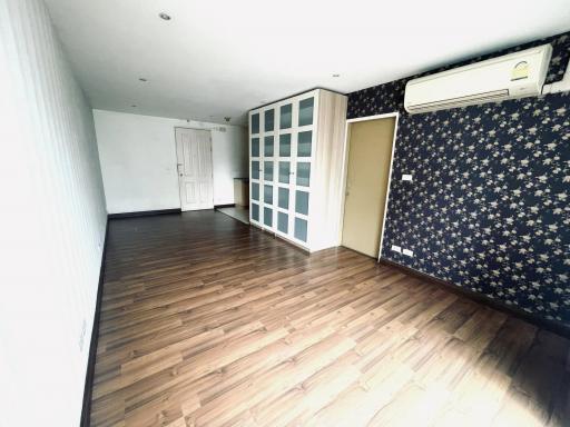 Spacious living room with dark wooden flooring and air conditioning