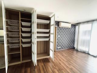 Spacious bedroom with open wardrobe and parquet flooring