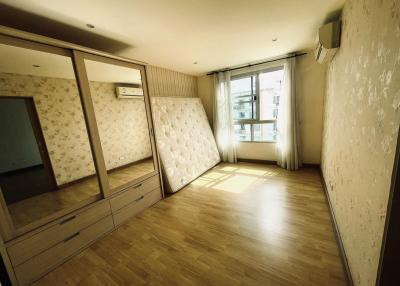 Spacious bedroom with large mirrored wardrobe and hardwood floors