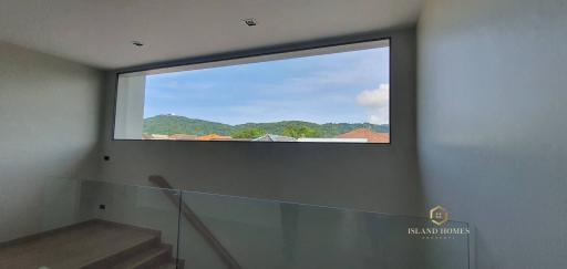 Staircase with glass railing and scenic window view