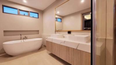 Modern spacious bathroom with a freestanding tub, large mirror, and elegant finishes