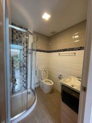 Modern bathroom with a shower cabin, toilet, and sink