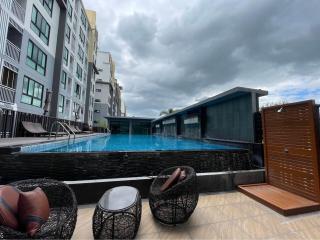 Swimming pool with lounging chairs and residential building in the background