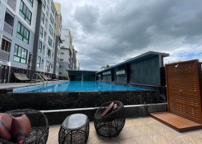 Swimming pool with lounging chairs and residential building in the background