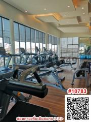 Indoor gym with cardio machines and floor-to-ceiling windows