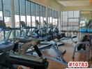 Indoor gym with cardio machines and floor-to-ceiling windows