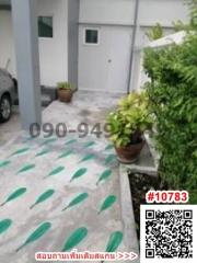 Exterior view of a home with a patterned driveway and greenery