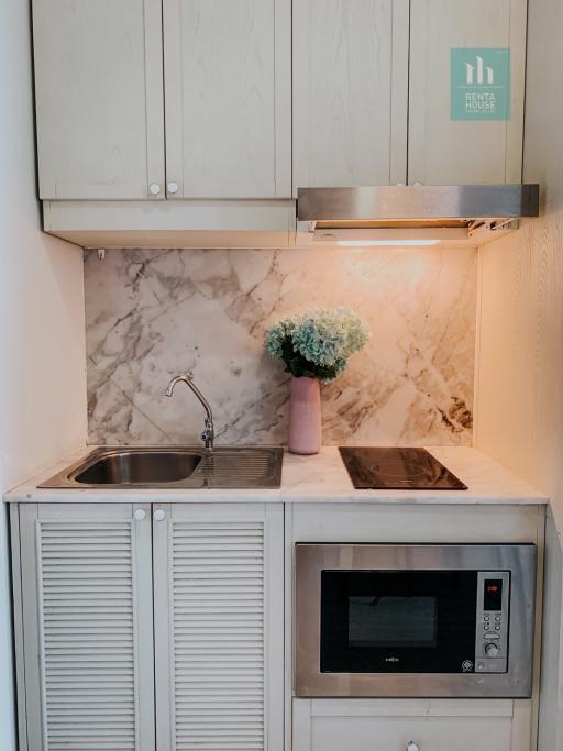 Compact modern kitchen with marble backsplash and stainless steel sink