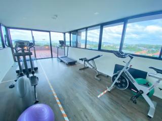 Spacious home gym with panoramic windows and various exercise equipment