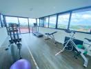 Spacious home gym with panoramic windows and various exercise equipment